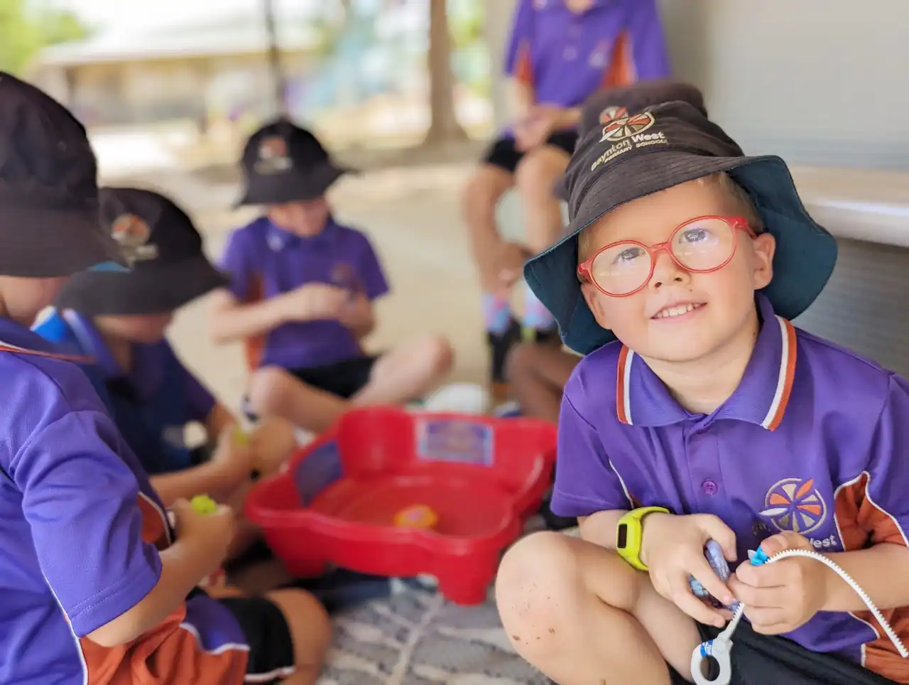 Student on right with red framed glasses looking towards viewer
